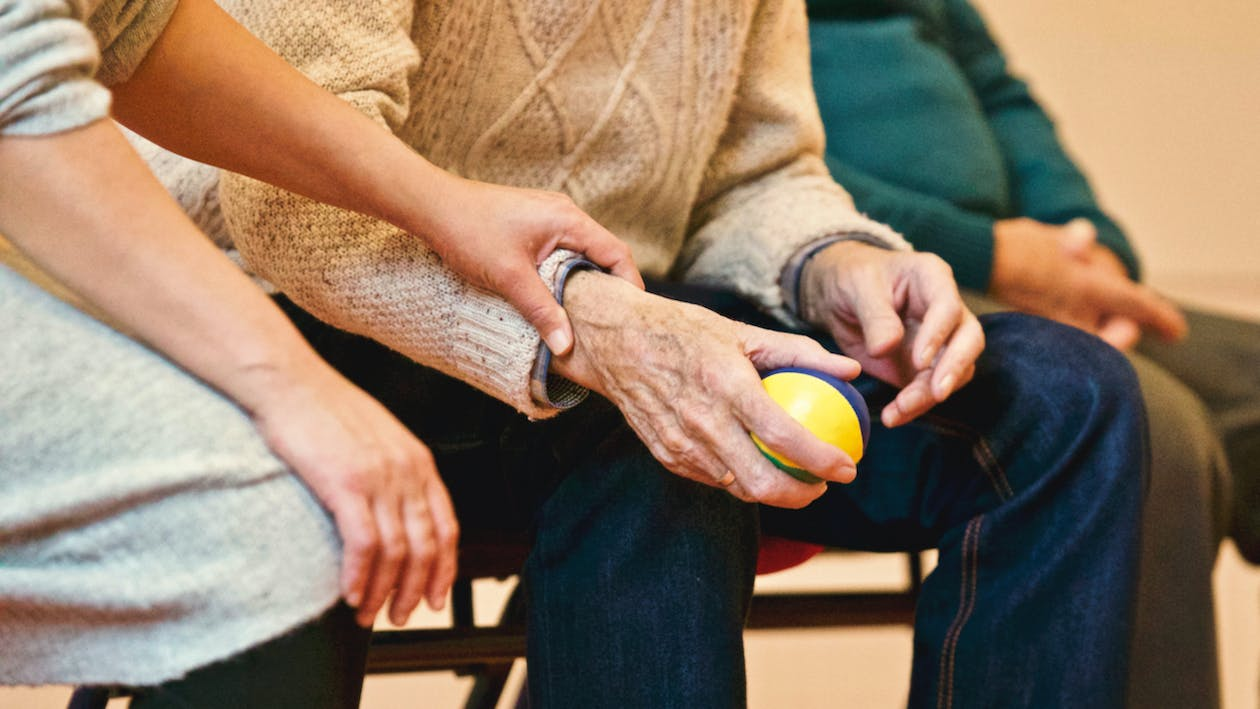 a senior adult holding a ball.