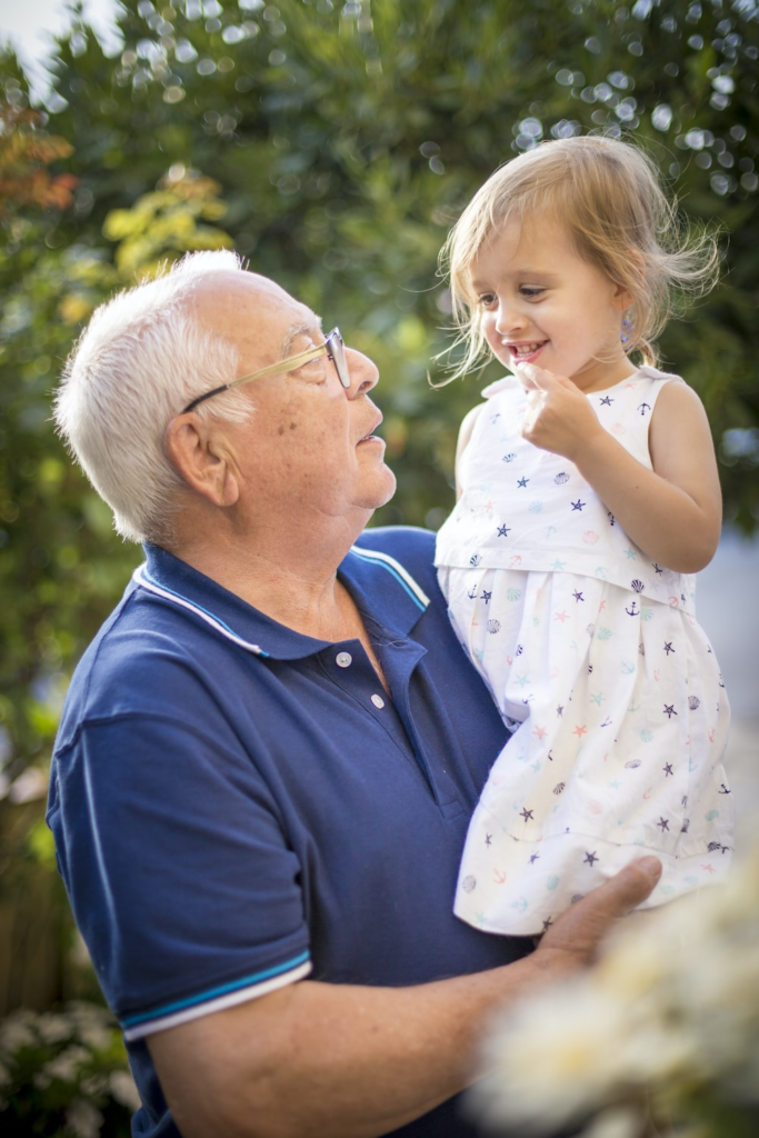 an elderly man holding a child.