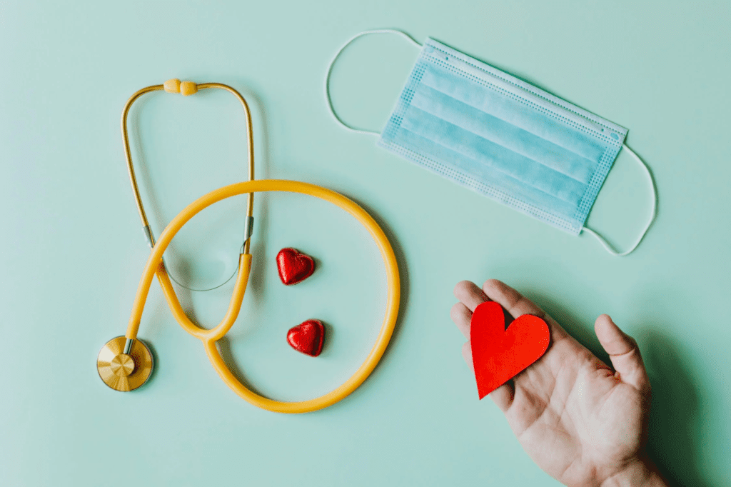 A flat-lay image of a stethoscope, mask, and hearts.