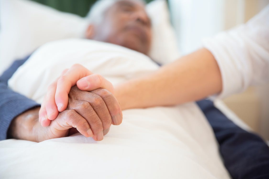 a man lying in bed, undergoing stroke recovery. 